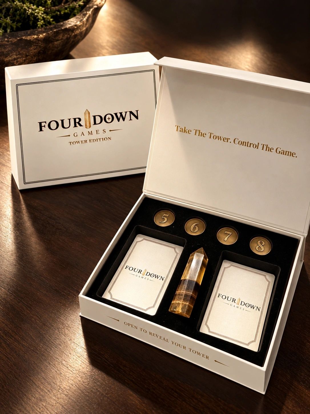 FOUR DOWN Tower Edition open game box with stone tower, cards, and Game Variation Tokens